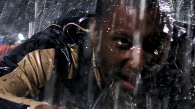 After a foul. Soccer player flying over wet ground in heavy rain